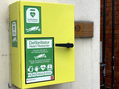 Abergavenny, Wales - Ekim 2022: Emergecny Heart, şehrin ana caddesindeki bir binanın dış duvarındaki bir kutuda defibrilatörü yeniden başlattı