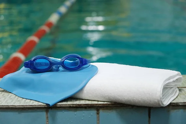 Zwembad. accessoire voor het zwembad - een handdoek, een rubberen kap en een zwembril. — Stockfoto