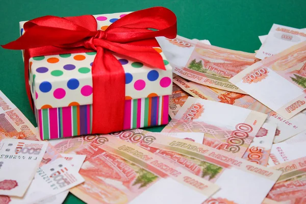 Geschenkdoos met rode strik tussen 5000 roebel Russische bankbiljetten — Stockfoto