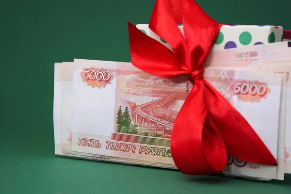 Russisch geld, 5000 roebel, geld als geschenk. Een bundel van vijfduizend Russische bankbiljetten met een rode strik. — Stockfoto