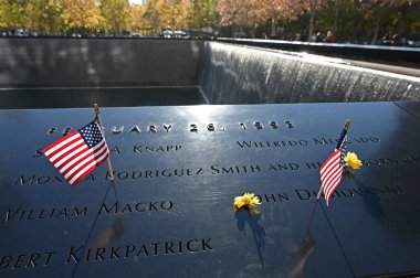 New York 'taki Dünya Ticaret Merkezi Anıtı' nda minyatür Amerikan bayrakları ve çiçekleri.