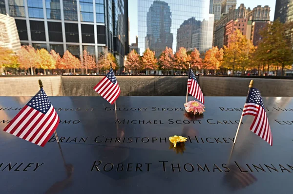 Miniatűr amerikai zászlók és virágok a World Trade Center Memorial New York-ban. — Stock Fotó