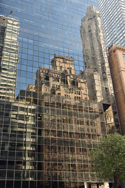 Building reflected in glass facade of modern building in New York City. Stock Photo