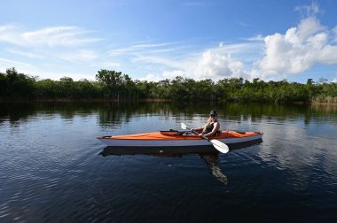 Everglades Ulusal Parkı 'ndaki Nine Mile Pond' da kayak yapan genç bir kadın..