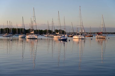 Şafak sökerken Coconut Grove açıklarında demirli yelkenliler..