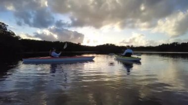 Everglades Ulusal Parkı 4K 'da kayak yapan aktif kıdemli ve genç bir kadın..