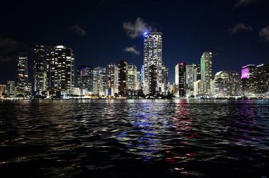 Miami, Florida gökdelenleri geceleyin Biscayne Körfezi 'ne yansıyor..