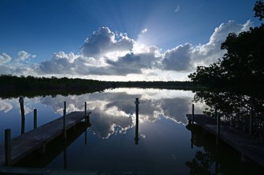 Güneşin doğuşuyla birlikte Everglades Ulusal Parkı 'ndaki West Lake' deki rıhtım ve sütunlar.