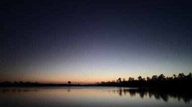 Everglades Ulusal Parkı 'nda gölün ve gökyüzünün alacakaranlık zamanı, Florida 4K.
