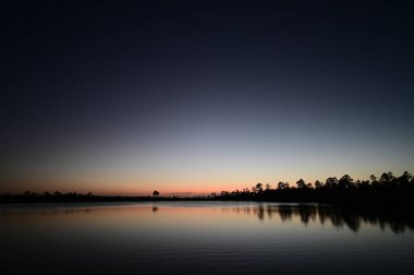 Florida, Everglades Ulusal Parkı 'ndaki Pine Glades Gölü üzerinde alacakaranlık sakin bir nisan akşamı.