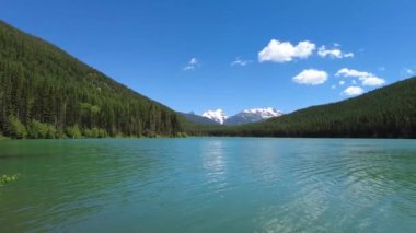 Stanton Gölü üzerinde açık yaz bulutları, Montana güneşli Haziran sabahı 4K.