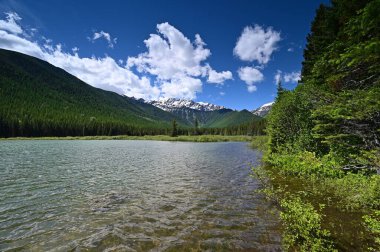 Güneşli yaz gününde Montana, Great Bear Wilderness 'da Stantion Gölü' nün arkasındaki karlı dağlar..