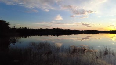 Colorful dawn cloudscape over Nine Mile Pond in Everglades National Park, Florida on calm summer morning 4K.