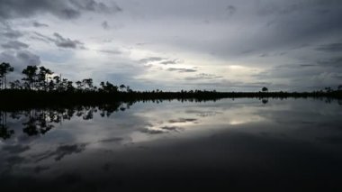 Everglades Ulusal Parkı 'ndaki Pine Glades Gölü üzerinde alacakaranlık bulutu zamanı, Florida 4K.