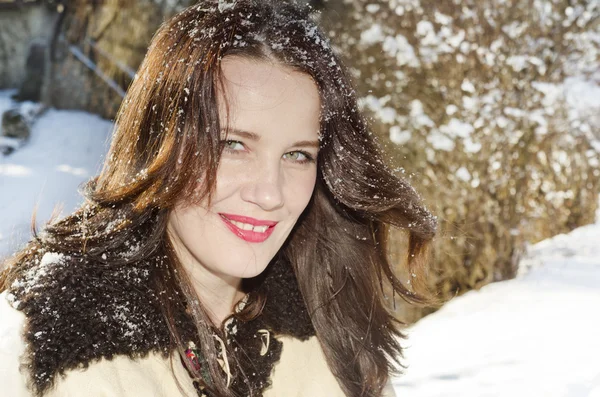 Mulher sorridente com neve no cabelo — Fotografia de Stock