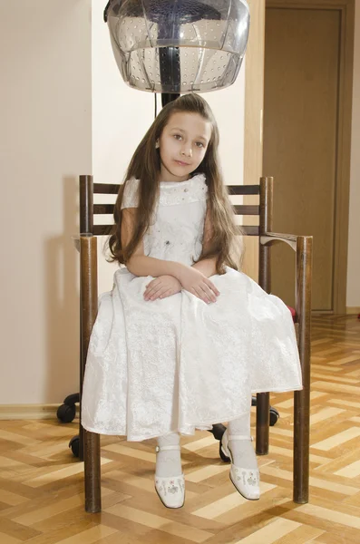 Young pretty girl is sitting in chair in hairdresser's — Stock Photo, Image