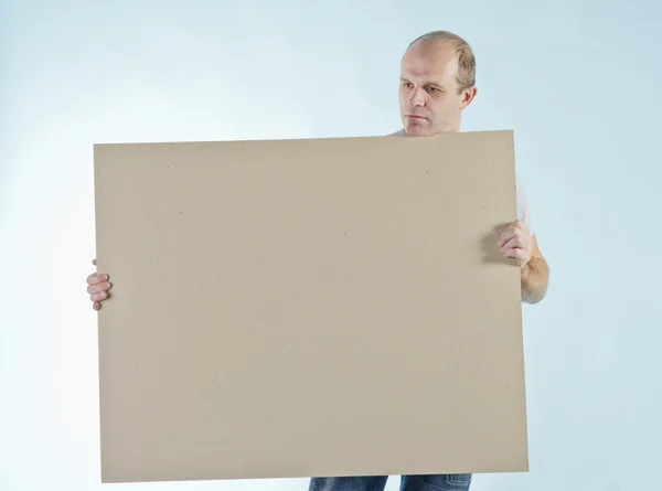 Portrait of man holding empty table to put words on blue backgro — Stock Photo, Image