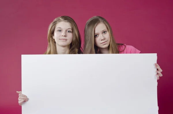 Portrait of girls holding empty poster — Stockfoto