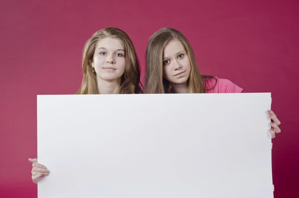 portrait of girls holding empty poster