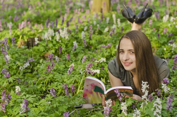 Portrait of beautiful girl with book in corydalis — Stock Photo, Image