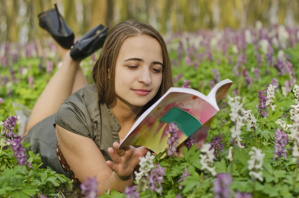 Portrait of beautiful girl with book in corydalis — Stock Photo, Image