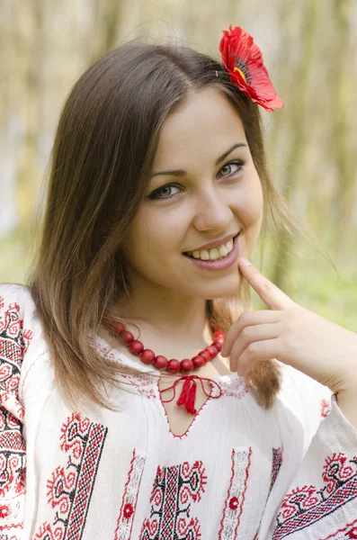 Retrato de bela menina sorridente com flor de papoula no cabelo — Fotografia de Stock