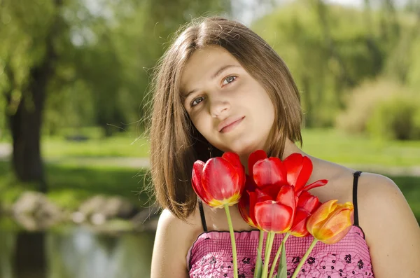 Porträt eines schönen Mädchens mit Tulpen — Stockfoto