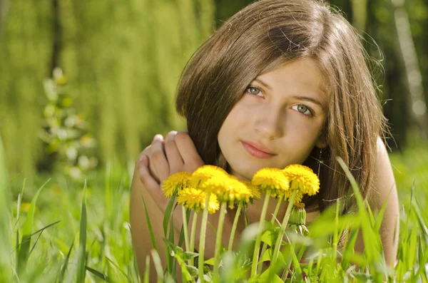 Portret van mooi meisje met paardebloemen — Stockfoto