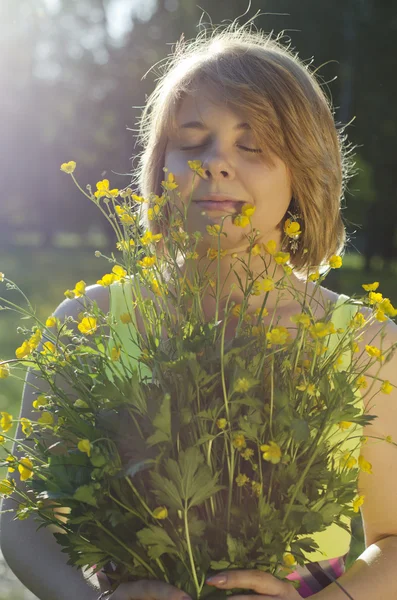 Güzel kız çiçek (buttercup) günbatımı ışık tutuyor — Stok fotoğraf