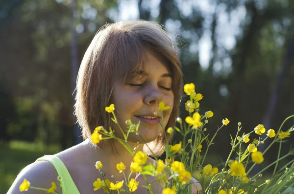 Krásná usměvavá dívka drží květ (Blatouch) v západu slunce — Stock fotografie