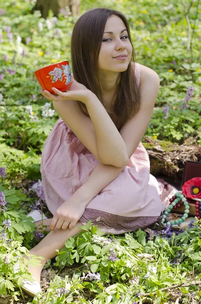 Hermosa chica sonriente está sosteniendo taza roja ornamentada —  Fotos de Stock