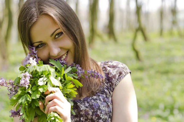 Portret van mooi lachende meisje met helmbloem — Stockfoto