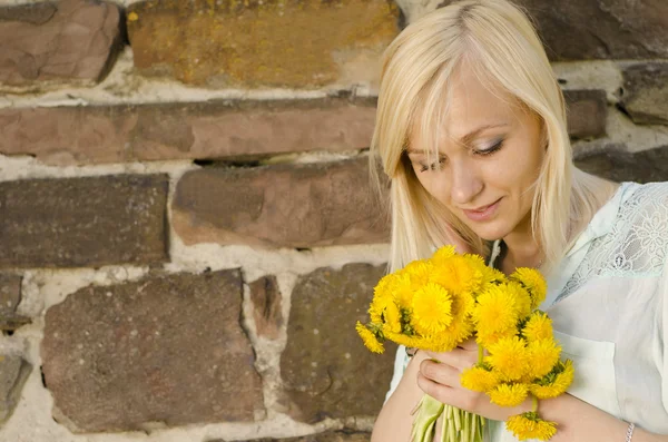 Portret van mooie blonde meisje met boeket van de paardebloem op s — Stockfoto