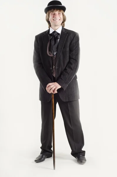 Studio portrait of a smiling business man with a cane in hands dressed in retro style — Stock Photo, Image