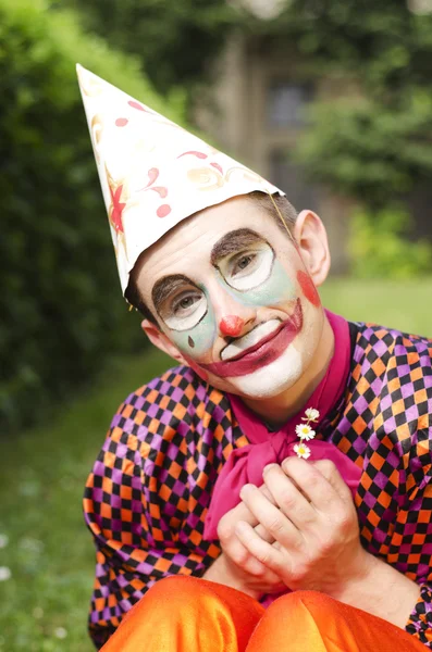 Portret mężczyzny z kwiatem, który jest ubrany jak clown — Zdjęcie stockowe