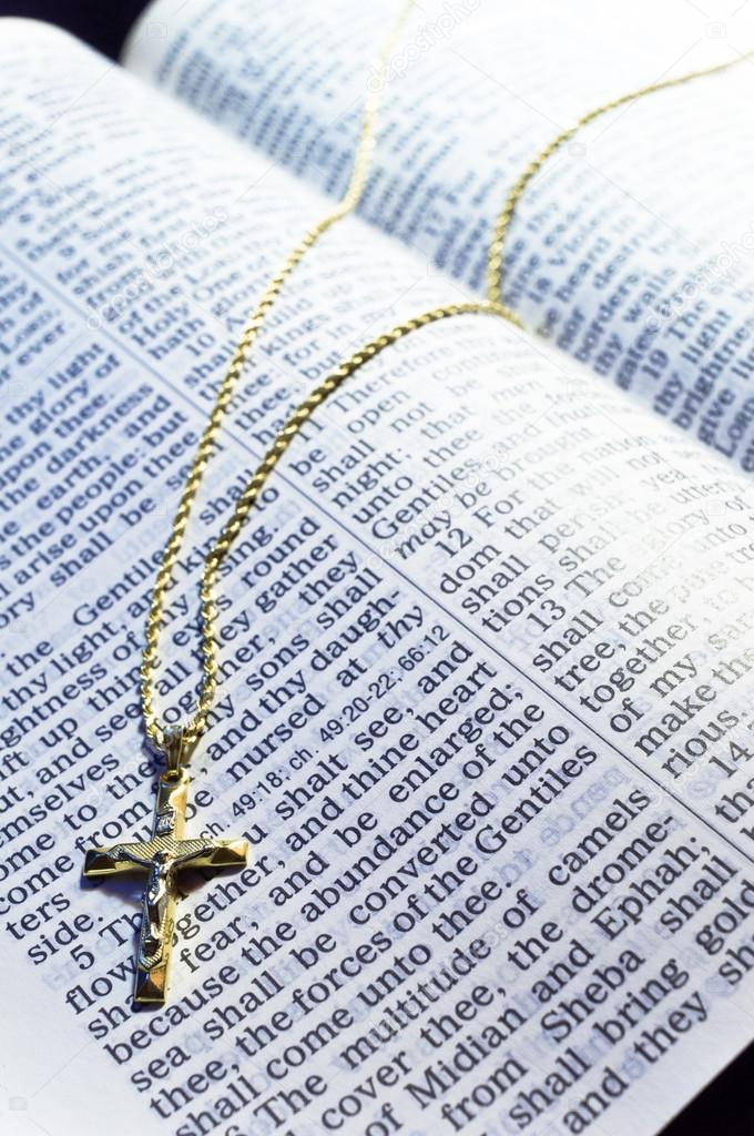 Golden Cross necklace on an open Bible