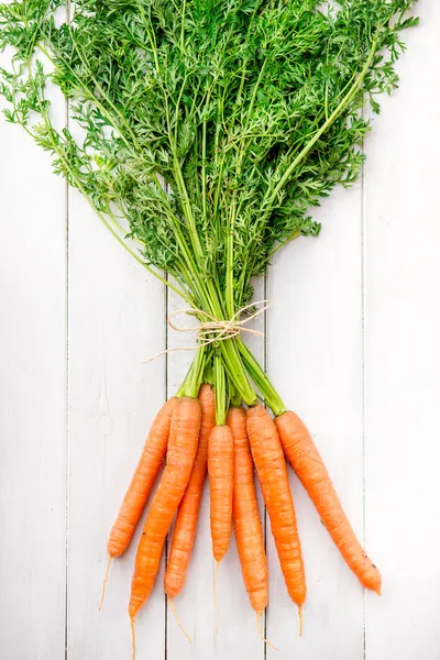 Young rustic carrots on white boards — Stock Photo, Image