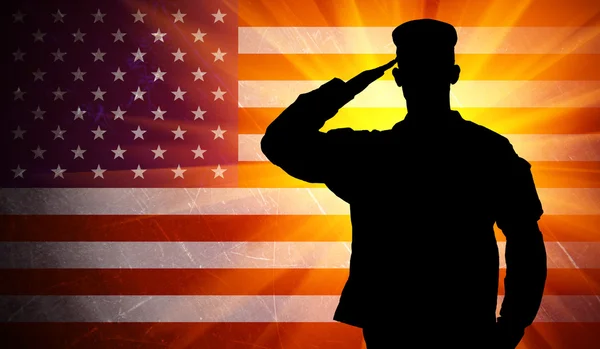 Proud saluting male army soldier on american flag background — Stock Photo, Image