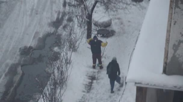 早朝の清掃員が通りで雪を掃除する — ストック動画