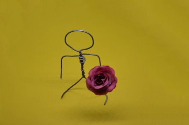 Bir nesneyle metal telden yapılmış insan figürü.