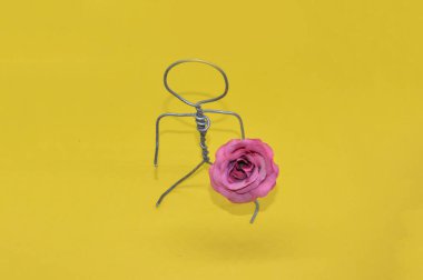 Bir nesneyle metal telden yapılmış insan figürü.