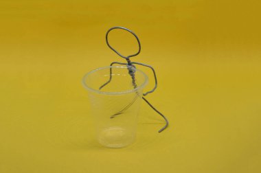 Bir nesneyle metal telden yapılmış insan figürü.