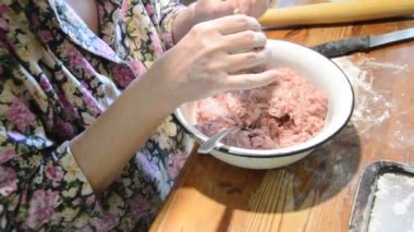 Kadın evde mantı heykeli yapıyor.