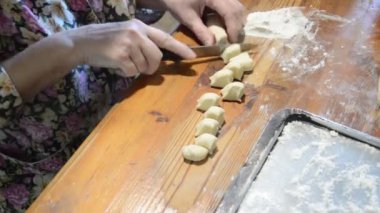 Kadın evde mantı heykeli yapıyor.