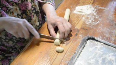 Kadın evde mantı heykeli yapıyor.