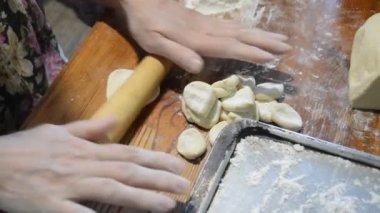Kadın evde mantı heykeli yapıyor.