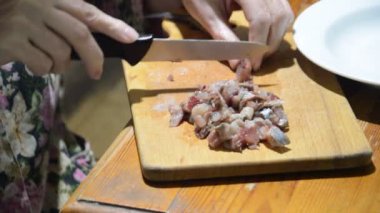 Mutfak tahtasındaki bıçakla ringa balığı dilimlemek.