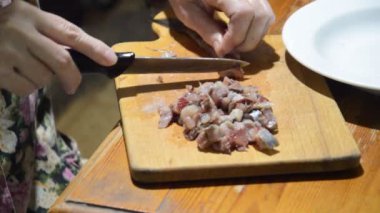 Mutfak tahtasındaki bıçakla ringa balığı dilimlemek.