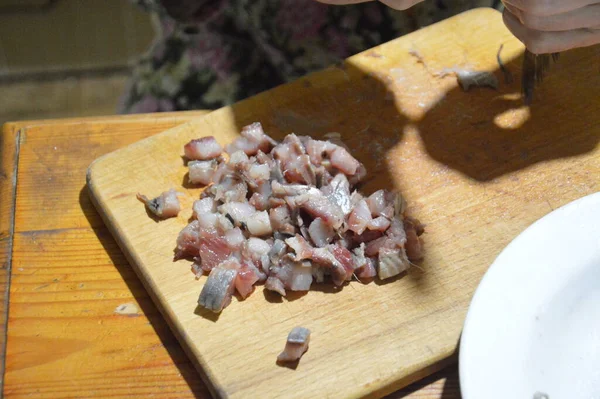 在厨房的木板上用刀割鲱鱼 — 图库照片
