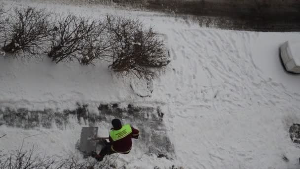 Hausmeister Räumt Mit Schaufel Schnee Auf Der Straße — Stockvideo